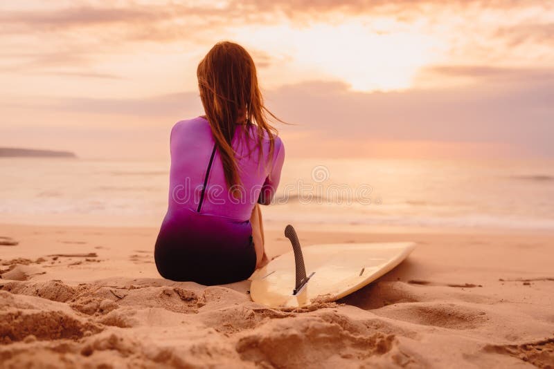 Κορίτσι Surfer με την ιστιοσανίδα σε μια παραλία στο ηλιοβασίλεμα στοκ εικόνα με δικαίωμα ελεύθερης χρήσης