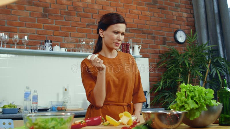 κορίτσι ετοιμάζει σαλάτα λαχανικών στην κουζίνα. γυναίκα που μυρίζει φρέσκια λυχνία κρεμμυδιού.
