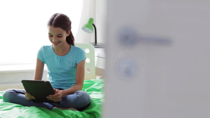 Κορίτσι με το PC ταμπλετών που έχει την τηλεοπτική συνομιλία στο σπίτι