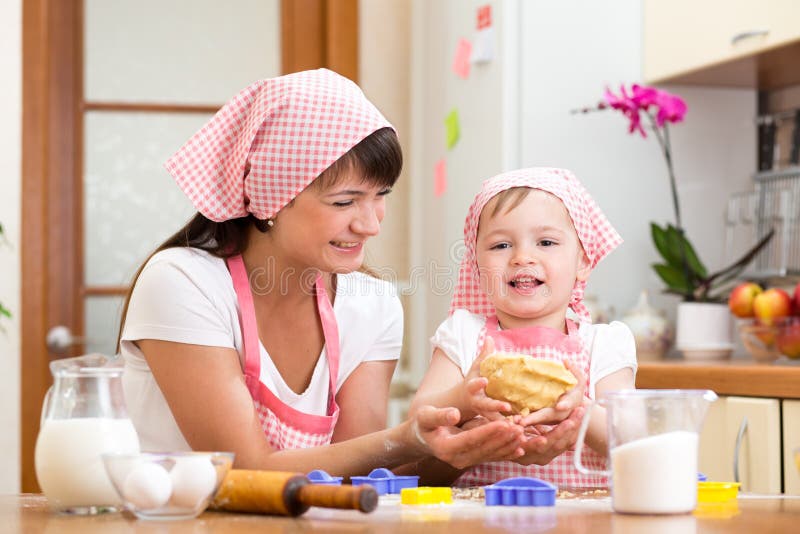 Κορίτσι παιδιών με το mom που κατασκευάζει τη ζύμη στην κουζίνα στοκ εικόνες με δικαίωμα ελεύθερης χρήσης Κορίτσι παιδιών με το mom που κατασκευάζει τη ζύμη στην κουζίνα στοκ εικόνες με δικαίωμα ελεύθερης χρήσης