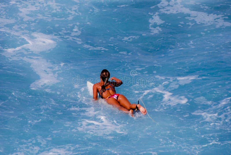 κορίτσι σύλληψης που κωπηλατεί surfer στο κύμα στοκ φωτογραφίες