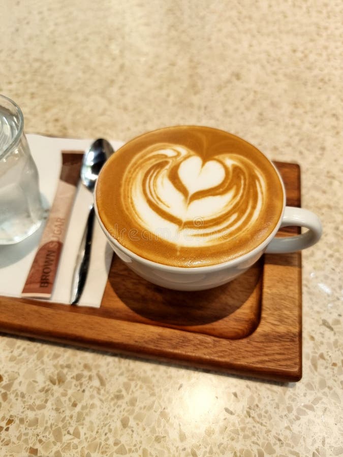 κορυφαία θέα ένα φλιτζάνι καφέ latart με πόσιμο νερό σε ένα ξύλινο πιάτο στοκ εικόνα με δικαίωμα ελεύθερης χρήσης