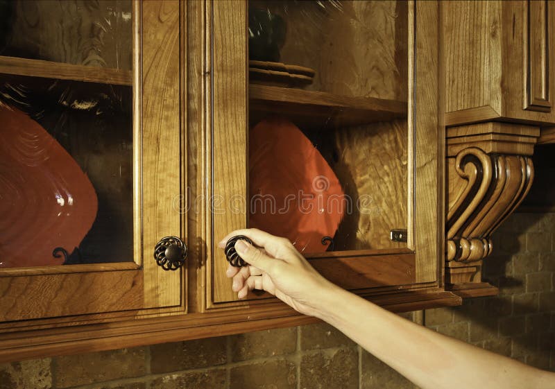 Female opening (or closing) kitchen cabinet door. Female opening (or closing) kitchen cabinet door.