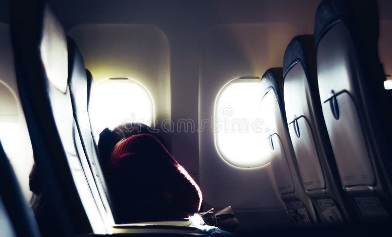 Κουρασμένη περιστασιακή μη αναγνωρίσιμη χιλιετής καυκάσια νέα γυναίκα κοιμισμένη στο κάθισμα διακινούμενος με το αεροπλάνο με φωτ στοκ εικόνες Κουρασμένη περιστασιακή μη αναγνωρίσιμη χιλιετής καυκάσια νέα γυναίκα κοιμισμένη στο κάθισμα διακινούμενος με το αεροπλάνο με φωτ στοκ εικόνες