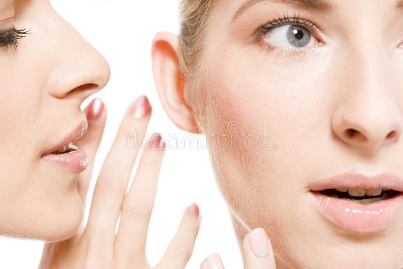 Two young women sharing their secrets, studio shot. Two young women sharing their secrets, studio shot