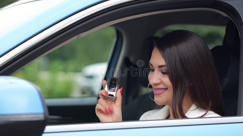κούκλα επιχειρηματίας δείχνει το κλειδί του νέου αυτοκινήτου χαμογελώντας στοκ φωτογραφίες