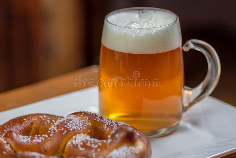 Κούπα γυαλιού της μπύρας και pretzel στοκ φωτογραφία Κούπα γυαλιού της μπύρας και pretzel στοκ φωτογραφία