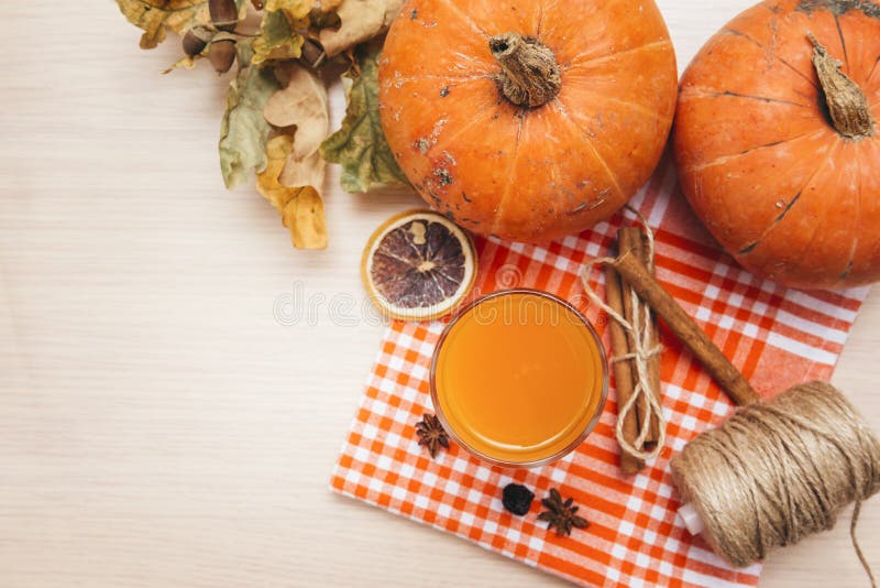 1 Cup pumpkin juice, cinnamon, dried orange slice, dry fallen leaves, pumpkin, top view, vegetable juice. 1 Cup pumpkin juice, cinnamon, dried orange slice, dry fallen leaves, pumpkin, top view, vegetable juice