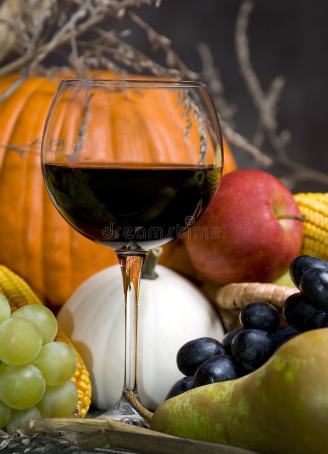 A glass of red wine with the autumn fruits. A glass of red wine with the autumn fruits