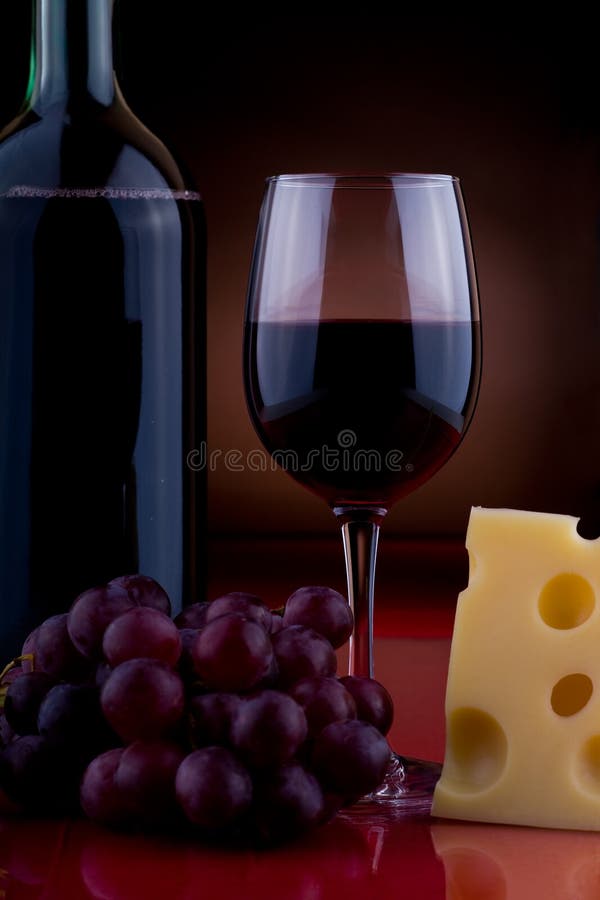 A wineglass and cheese on the table. A wineglass and cheese on the table