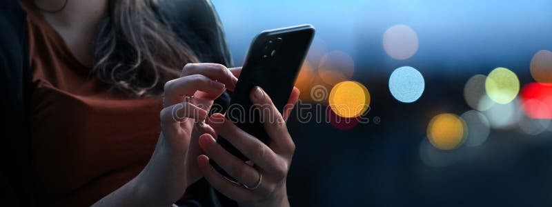κρατώντας το smartphone τη νύχτα γεμάτο φώτα στοκ φωτογραφία με δικαίωμα ελεύθερης χρήσης