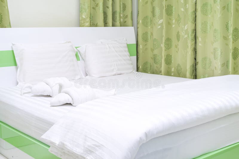 Bed with decorative towel - fold to be duck with green curtain room. Bed with decorative towel - fold to be duck with green curtain room