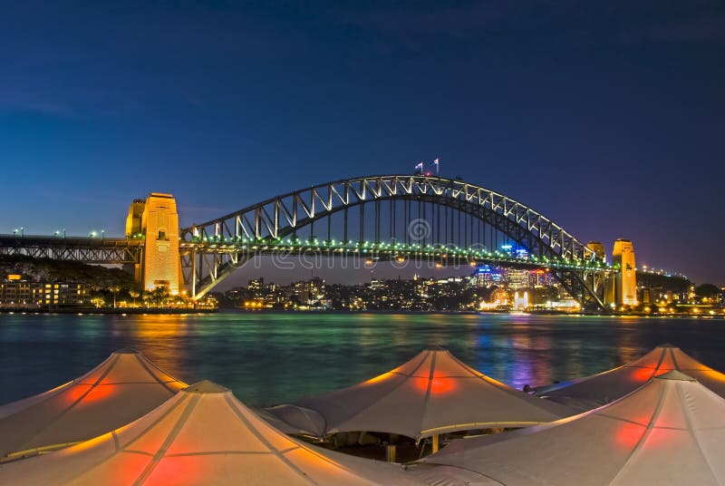 Sydney Harbour Bridge viewed from Circular Quay from behind lighted umbrellas. Sydney Harbour Bridge viewed from Circular Quay from behind lighted umbrellas