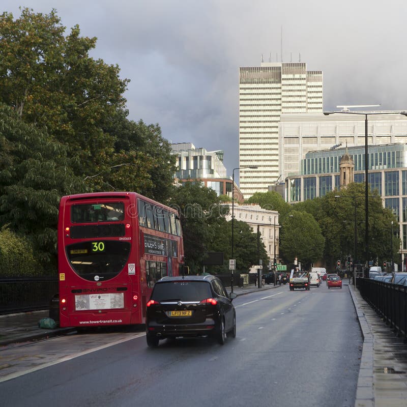 LONDON, ENGLAND - JULY 12, 2016 red London buses during the rush hour in central London taking passengers to and from work and shopping crossing a box junction. LONDON, ENGLAND - JULY 12, 2016 red London buses during the rush hour in central London taking passengers to and from work and shopping crossing a box junction