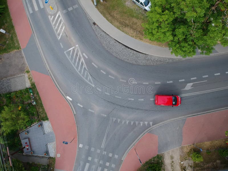 Κόκκινη οδήγηση αυτοκινήτων πέρα από την κυρτή διατομή στην πόλη, εναέρια άποψη στοκ φωτογραφία με δικαίωμα ελεύθερης χρήσης Κόκκινη οδήγηση αυτοκινήτων πέρα από την κυρτή διατομή στην πόλη, εναέρια άποψη στοκ φωτογραφία με δικαίωμα ελεύθερης χρήσης