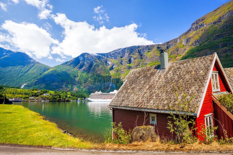 Red cottage against cruise ship in fjord, famous Flam, Norway. Red cottage against cruise ship in fjord, famous Flam, Norway