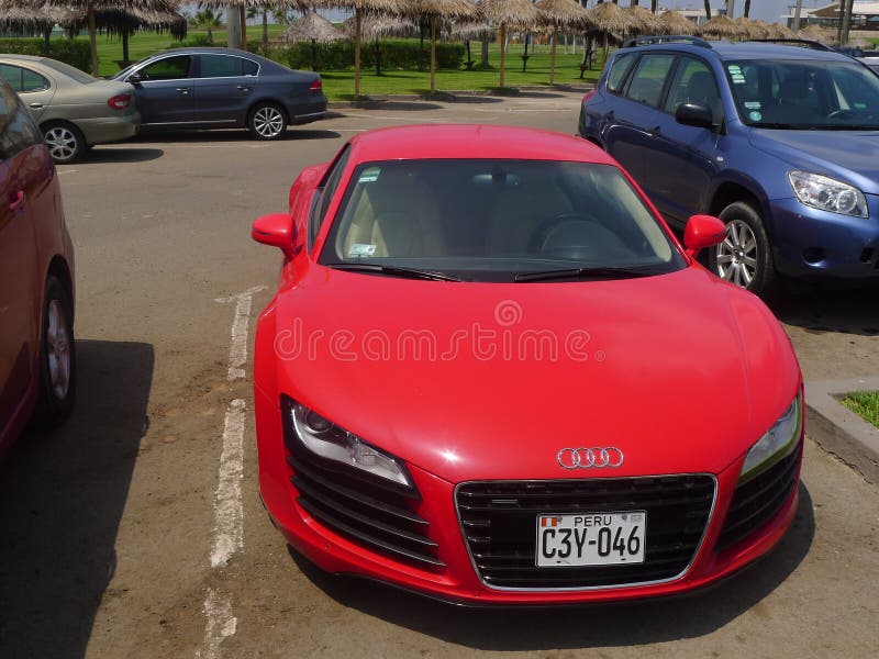 Lima, Peru. April 2, 2016. Front view of a parked red color two doors Audi R8 V8 FSi coupe. This version of the german Audi R8 is the top of the line of Audi. It is a mint condition super sport car. Lima, Peru. April 2, 2016. Front view of a parked red color two doors Audi R8 V8 FSi coupe. This version of the german Audi R8 is the top of the line of Audi. It is a mint condition super sport car.