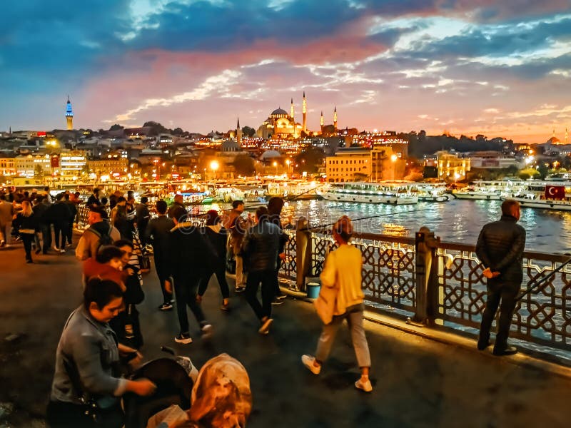 κόσμος περπατά στη γέφυρα γκαλάτα πάνω από τον κόλπο του χρυσού κέρατος στην ιστανμπούλ τη νύχτα στοκ φωτογραφία