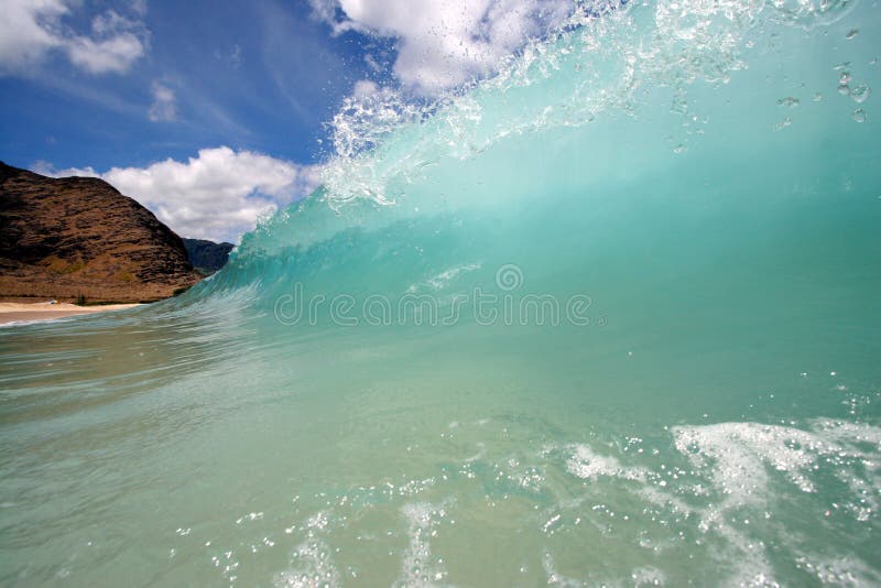 A wave breaks along a scenic backdrop. A wave breaks along a scenic backdrop