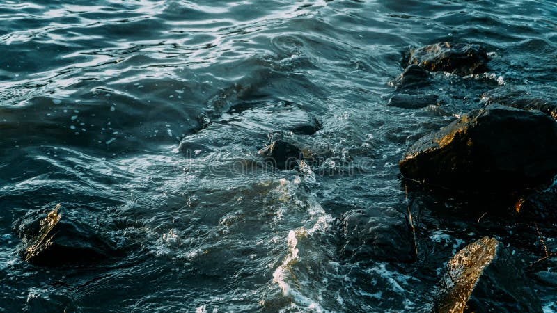 Κύματα θαλασσίου νερού που εκτοξεύονται στους βράχους στοκ εικόνα Κύματα θαλασσίου νερού που εκτοξεύονται στους βράχους στοκ εικόνα