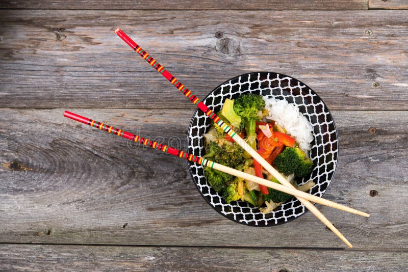 Κύπελλο με τα λαχανικά, το ρύζι και chopsticks στοκ φωτογραφίες με δικαίωμα ελεύθερης χρήσης Κύπελλο με τα λαχανικά, το ρύζι και chopsticks στοκ φωτογραφίες με δικαίωμα ελεύθερης χρήσης