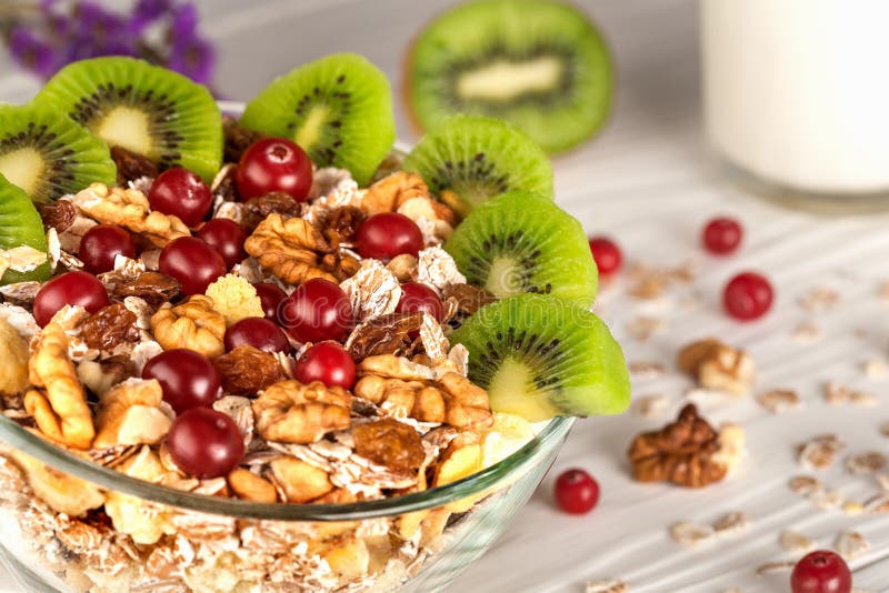 Κύπελλο του muesli με τα καρύδια του ακτινίδιου στο ξύλινο υπόβαθρο στοκ φωτογραφία με δικαίωμα ελεύθερης χρήσης Κύπελλο του muesli με τα καρύδια του ακτινίδιου στο ξύλινο υπόβαθρο στοκ φωτογραφία με δικαίωμα ελεύθερης χρήσης