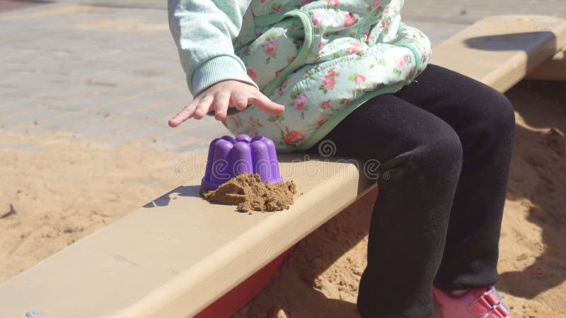 Λίγο όμορφο καυκάσιο κορίτσι 3 χρονών παίζει σε ένα Sandbox με τα παιχνίδια και τα Sandbox, παιδική χαρά