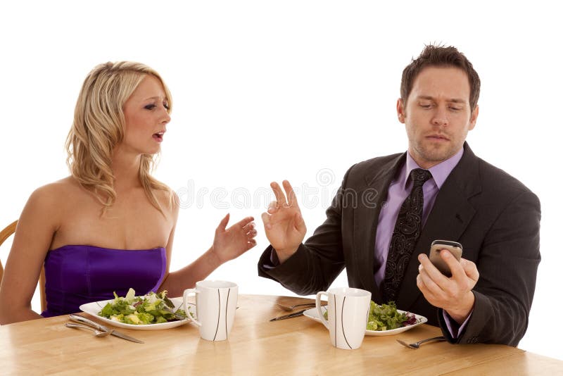 A men telling his date to hold on while he checks his phone for a text message. A men telling his date to hold on while he checks his phone for a text message.
