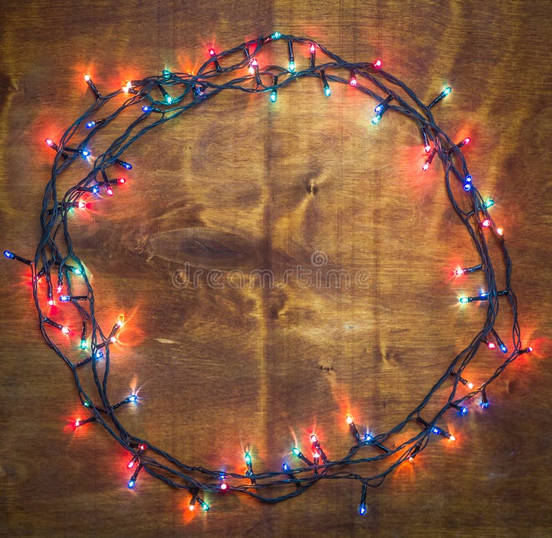 Λαμπερά φώτα για τις γιορτές Xmas στρογγυλεμένα σε ξύλινο φόντο στοκ φωτογραφίες Λαμπερά φώτα για τις γιορτές Xmas στρογγυλεμένα σε ξύλινο φόντο στοκ φωτογραφίες