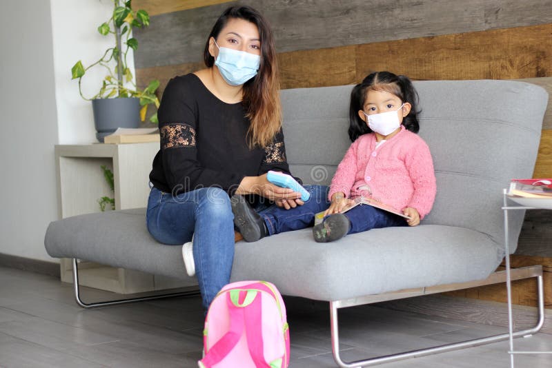 The Latin mom with 2-year-old girl putting on protective face masks for new normality covid-19. The Latin mom with 2-year-old girl putting on protective face masks for new normality covid-19