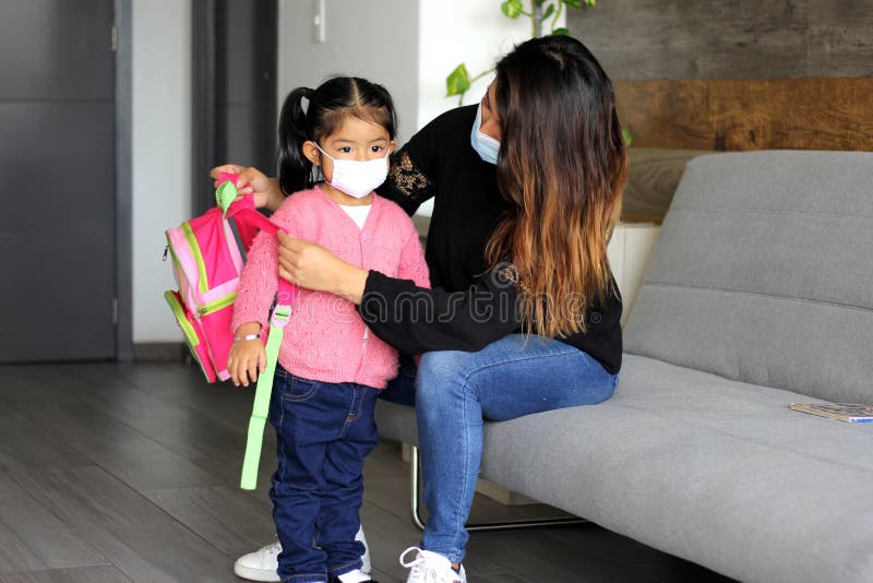 The Latin mom with 2-year-old girl putting on protective face masks for new normality covid-19. The Latin mom with 2-year-old girl putting on protective face masks for new normality covid-19