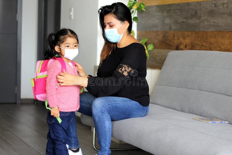 The Latin mom with 2-year-old girl putting on protective face masks for new normality covid-19. The Latin mom with 2-year-old girl putting on protective face masks for new normality covid-19