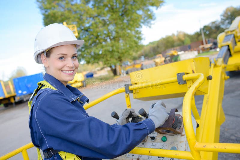 Woman operating controls of cherry picker bucket. Woman operating controls of cherry picker bucket