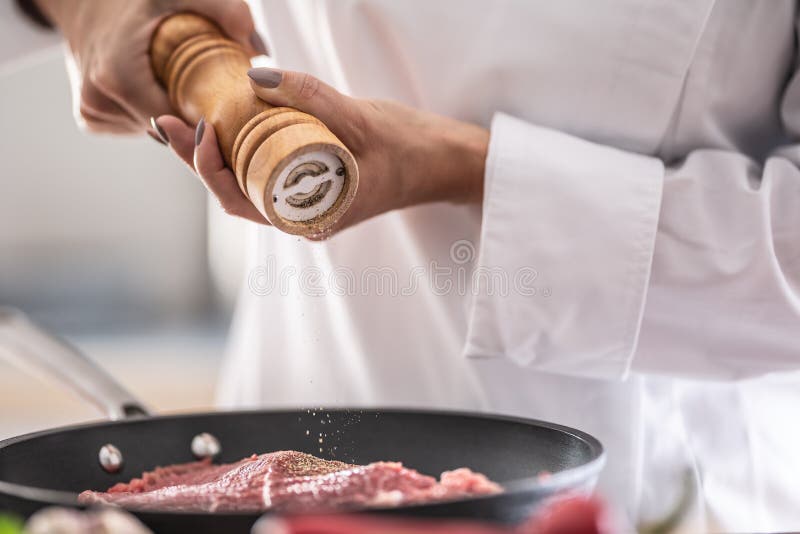 λεπτομέρεια ξύλινου λειαντήρα που βάζει μπαχαρικά σε τεμάχια χοιρινού κρέατος σε τηγάνι στοκ φωτογραφία με δικαίωμα ελεύθερης χρήσης