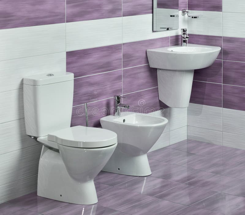 Detail of modern bathroom with sink, toilet and bidet, with purple and white tiles and miror. Detail of modern bathroom with sink, toilet and bidet, with purple and white tiles and miror