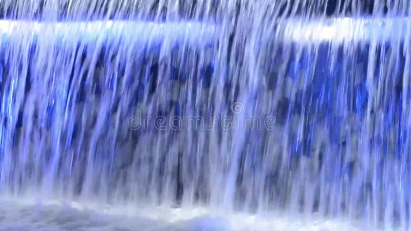 λεπτομέρειες για την πτώση του νερού στο γαλάζιο φωτεινό συντριβάνι καταρράκτη τη νύχτα