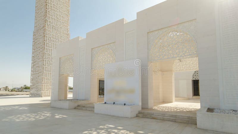 Entrance to white mosque in Ajman timelapse hyperlapse with sun flares, United Arab Emirates. Entrance to white mosque in Ajman timelapse hyperlapse with sun flares, United Arab Emirates