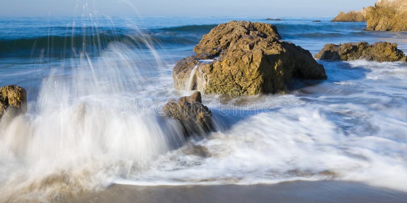 This is an image shot in the early morning of wild surf pounding against a rocky and secluded beach in Malibu, California. This is an image shot in the early morning of wild surf pounding against a rocky and secluded beach in Malibu, California.