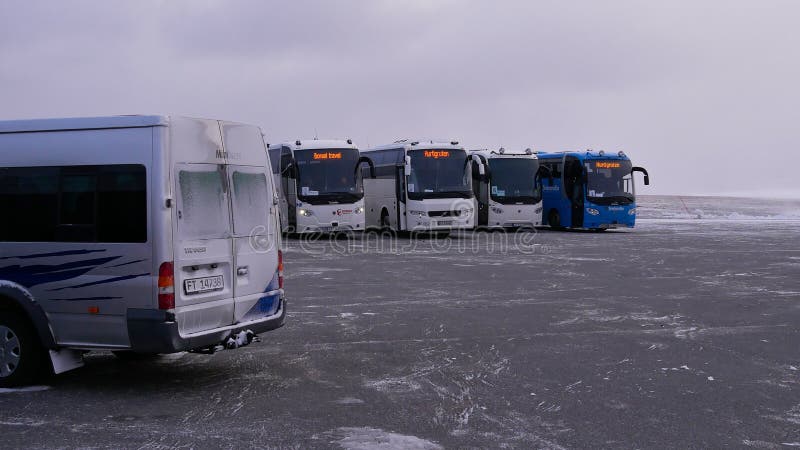 Nordkapp, Norway - 02 28 2019: Buses waiting for tourists on the parking of North Cape to bring them back to their Hurtigruten cruise ship. Nordkapp, Norway - 02 28 2019: Buses waiting for tourists on the parking of North Cape to bring them back to their Hurtigruten cruise ship.