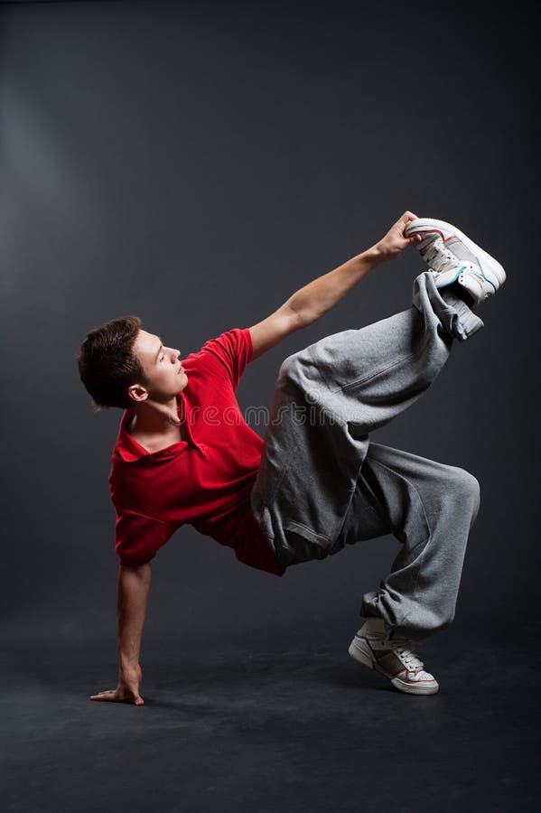 Hip-hop guy dancing against dark background. Hip-hop guy dancing against dark background