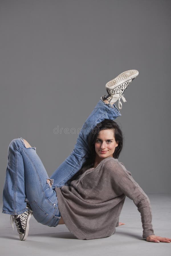 Hip hop dancer in denim jeans over grey background. Hip hop dancer in denim jeans over grey background