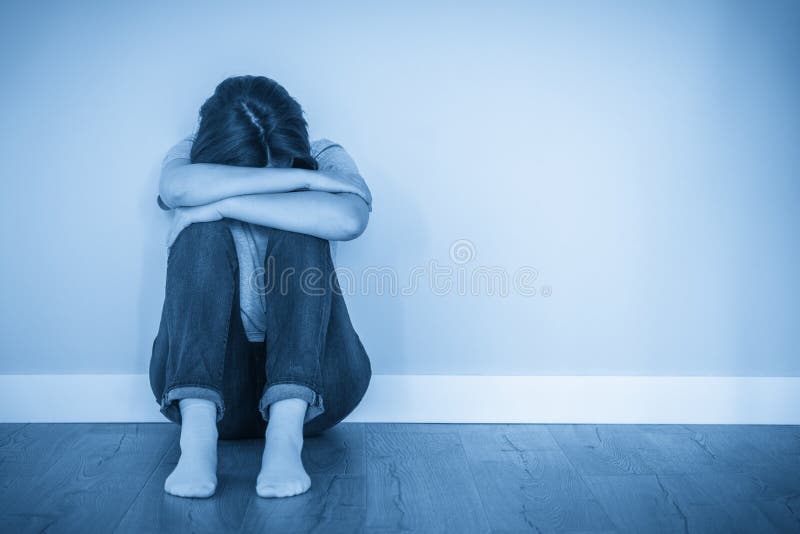 λυπημένη γυναίκα που κάθεται σε ένα πάτωμα μόνη της σε άδειο δωμάτιο απελπισμένη και μοναχική ιδέα με χώρο αντιγραφής