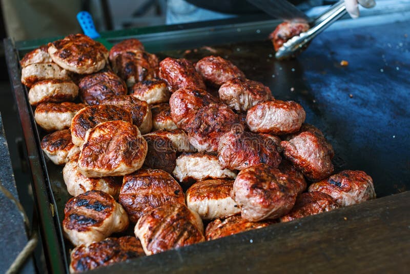 Μάγειρας που καθιστά τα burgers υπαίθρια στο γεγονός φεστιβάλ τροφίμων οδών στοκ εικόνες Μάγειρας που καθιστά τα burgers υπαίθρια στο γεγονός φεστιβάλ τροφίμων οδών στοκ εικόνες