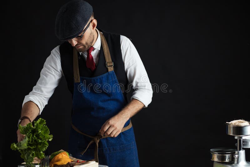 Μάγειρας που προσθέτει το μαρούλι burger Προετοιμασία burger στοκ φωτογραφίες με δικαίωμα ελεύθερης χρήσης Μάγειρας που προσθέτει το μαρούλι burger Προετοιμασία burger στοκ φωτογραφίες με δικαίωμα ελεύθερης χρήσης