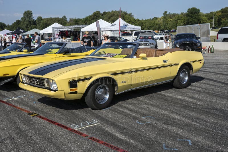 Sanair august 9, 2014 front side view of yellow mustang convertible with top down and ginger interior color at 19e super ford show. Sanair august 9, 2014 front side view of yellow mustang convertible with top down and ginger interior color at 19e super ford show.