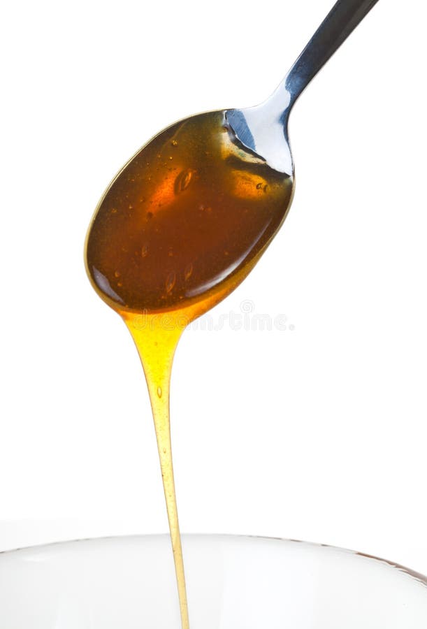 Honey dripping from a spoon, isolated on a white background. Honey dripping from a spoon, isolated on a white background