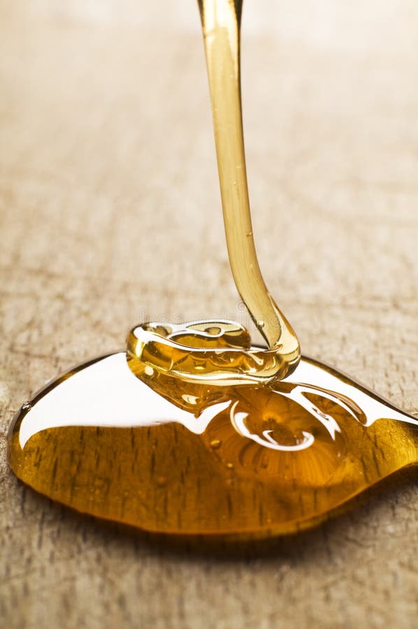 Wild yellow honey pouring close up shoot. Wild yellow honey pouring close up shoot