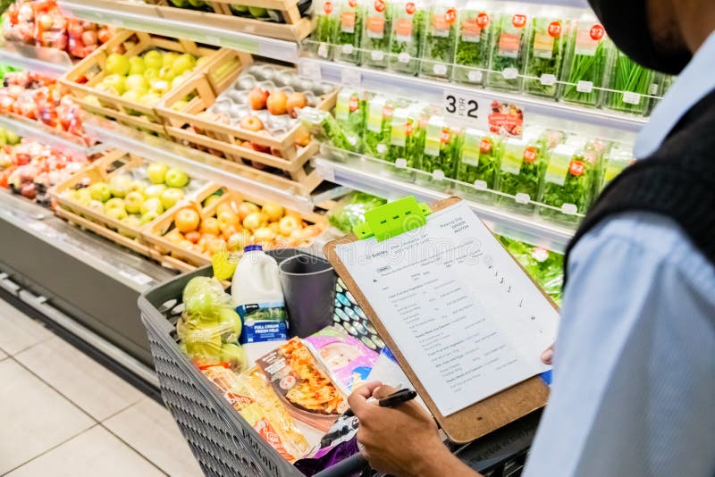 Cape Town, South Africa - December 10, 2020: Staff member picking grocery products from shelf for express home delivery service at local Pick n Pay supermarket. Cape Town, South Africa - December 10, 2020: Staff member picking grocery products from shelf for express home delivery service at local Pick n Pay supermarket