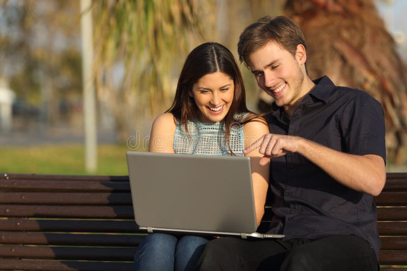 Μέσα προσοχής ζεύγους σε μια συνεδρίαση lap-top σε έναν πάγκο στοκ εικόνες με δικαίωμα ελεύθερης χρήσης Μέσα προσοχής ζεύγους σε μια συνεδρίαση lap-top σε έναν πάγκο στοκ εικόνες με δικαίωμα ελεύθερης χρήσης