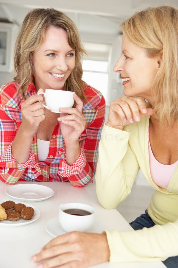 Μέσες γυναίκες ηλικίας που κουβεντιάζουν πέρα από τον καφέ στο σπίτι